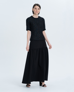 The tunic of a semi-fitting silhouette is made of black textured tweed, embroidered with small colored sequins. A neat round neck and a V-neck sleeve to the elbow are trimmed with black braid. On the middle seam of the back of the tunic is a metal zi