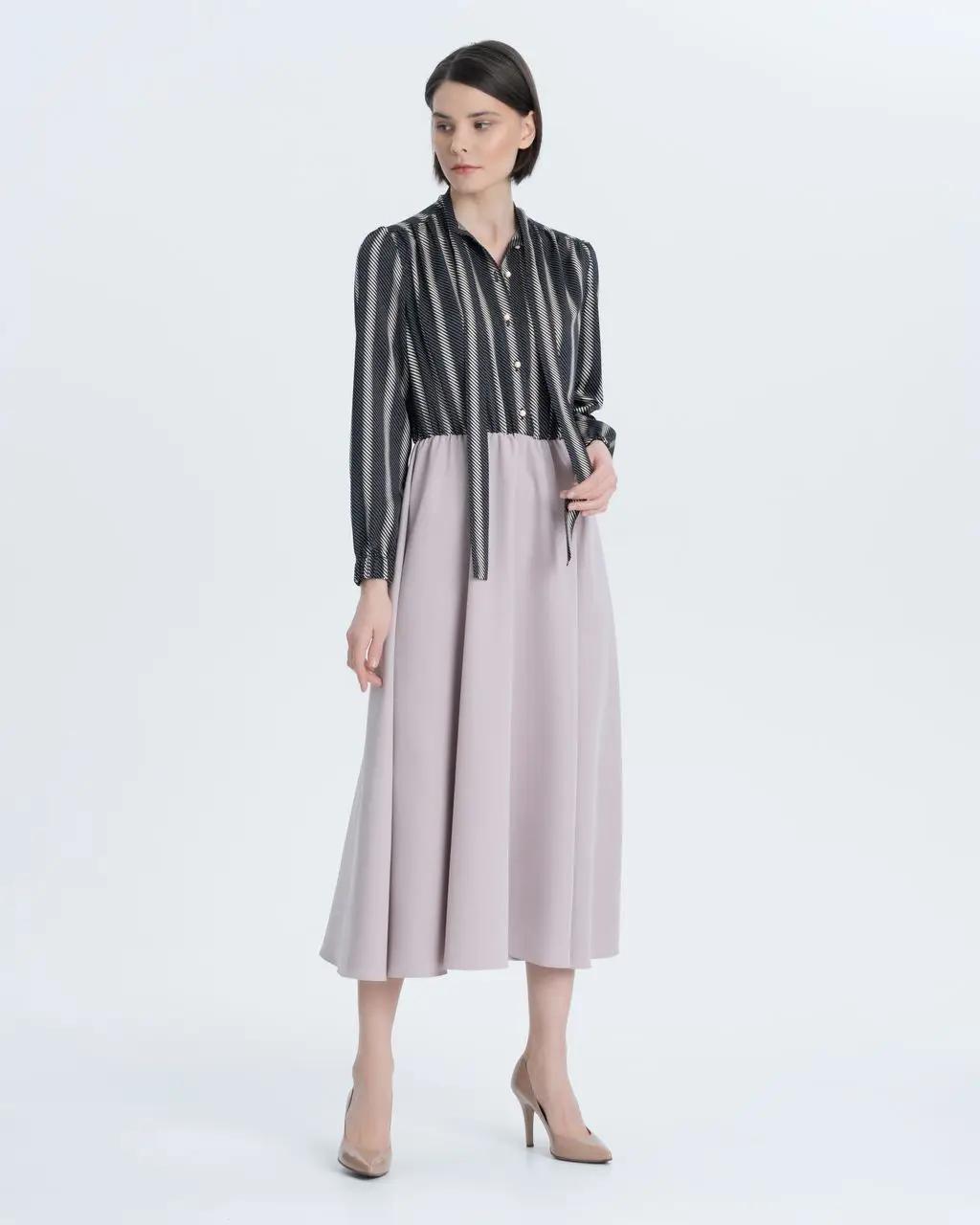 An elegant urban dress, gathered at the waist and made from a combination of two fabrics: plain and with an original geometric print. Elegant neckline, ribbons and gathered at the cuffs of the sleeve.