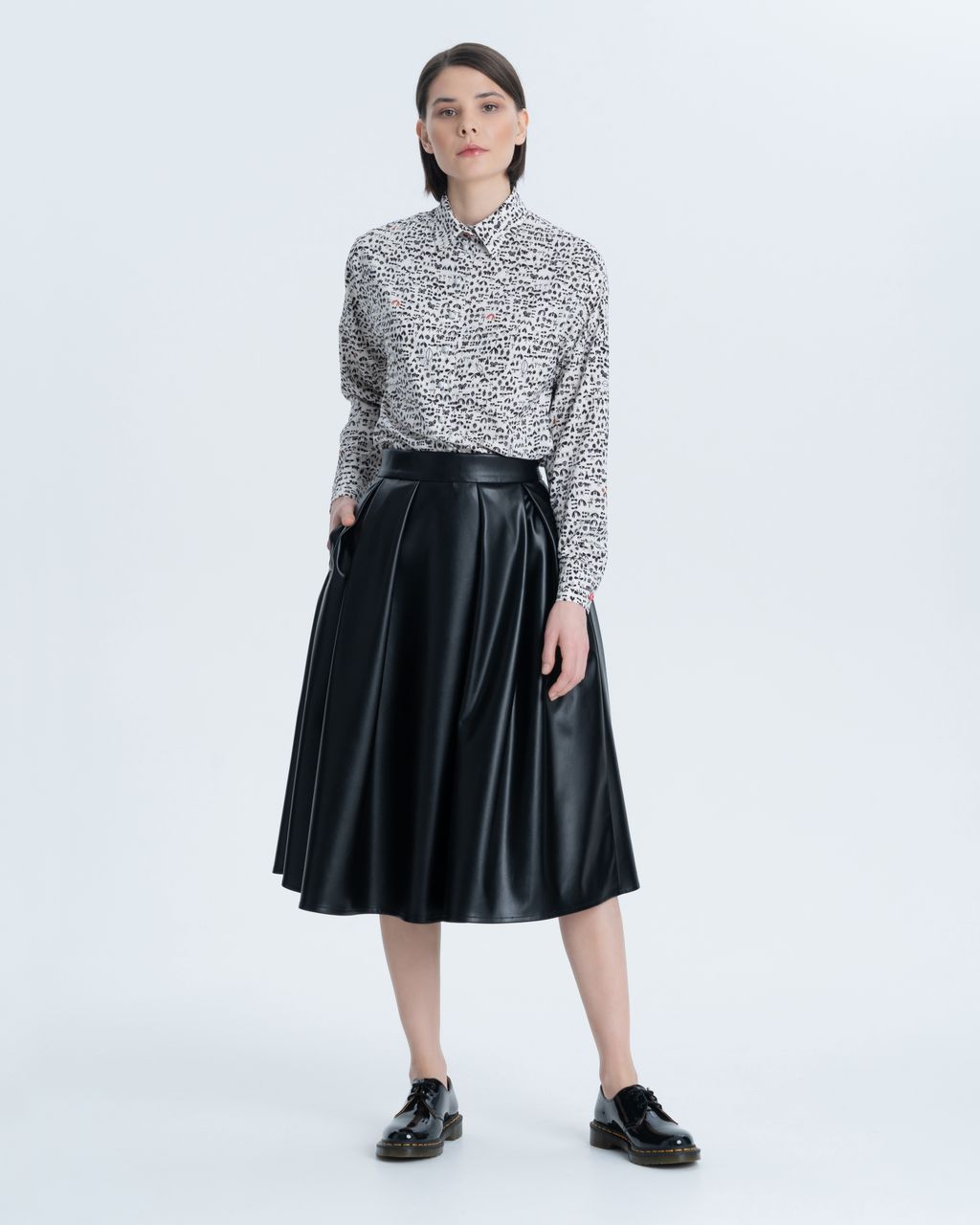 Elongated blouse in a loose silhouette with side seams moved forward. A turn-down collar, a thin graphic print in the form of beetles and moths, cuffs and placket with original volume buttons give it a special chic.