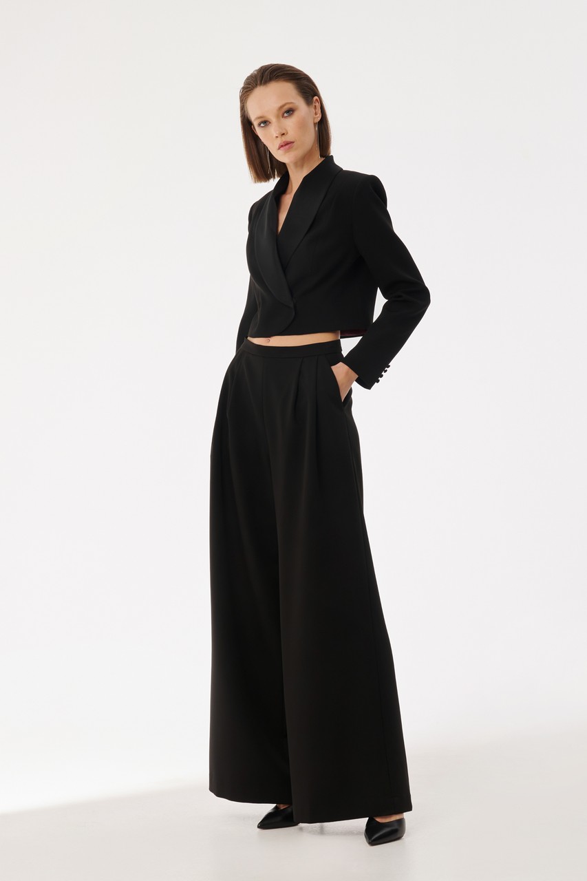 Stylish flowing trousers in loose crepe, silhouette with two tucks and pockets at the waist. Trousers can make up a set for both evening and casual looks.
