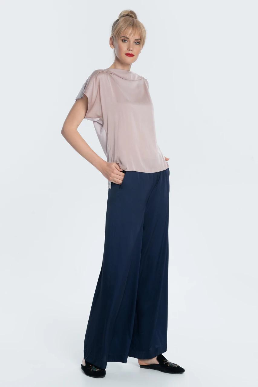 Comfortable chic — flowy satin trousers in a free, flying silhouette with two tucks and pockets at the waist. Trousers can make up a set for both evening and casual looks.
