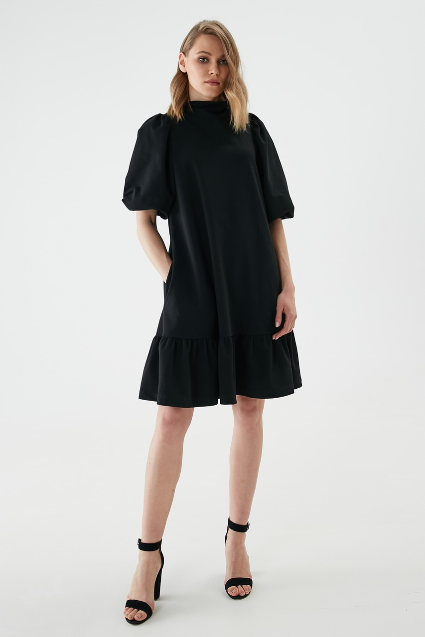 Comfortable knitted dress with a loose stand-up neckline. The sleeve along the shoulder line, cuff and flounce are gathered together to create an original and expressive silhouette. Dress with side seam pockets.