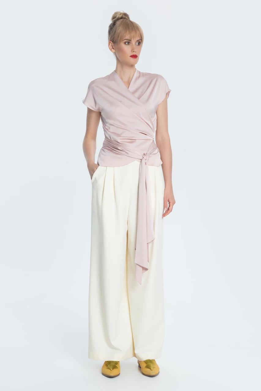 Stylish flowing trousers in loose crepe, silhouette with two tucks and pockets at the waist. Trousers can make up a set for both evening and casual looks.