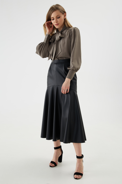 Silhouette skirt lined with eco-leather with wide asymmetrical flounce. The waistline is decorated with a belt and tucks, the fastener is with a metal zipper on the back.