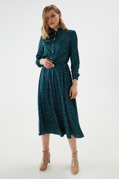 A polka-dot satin dress gathered at the waist. Sleeve and yoke with light gathers and elastic cuffs. Placket fastening with accent buttons on the leg and stand-up collar